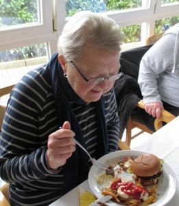 Bewohner im Haus Karin lassen sich selbstgemachte Hamburger schmecken. Foto: Heinrichs Gruppe